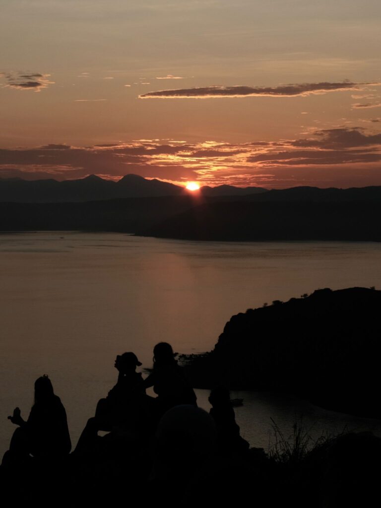 Silhoutte of people against sunrise at Padar Island